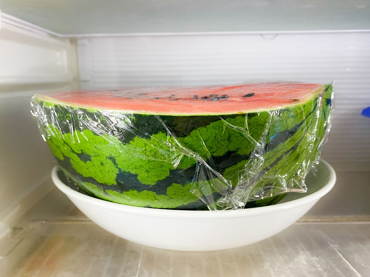 冷蔵庫内で皿にのせてラップ保存されるスイカ