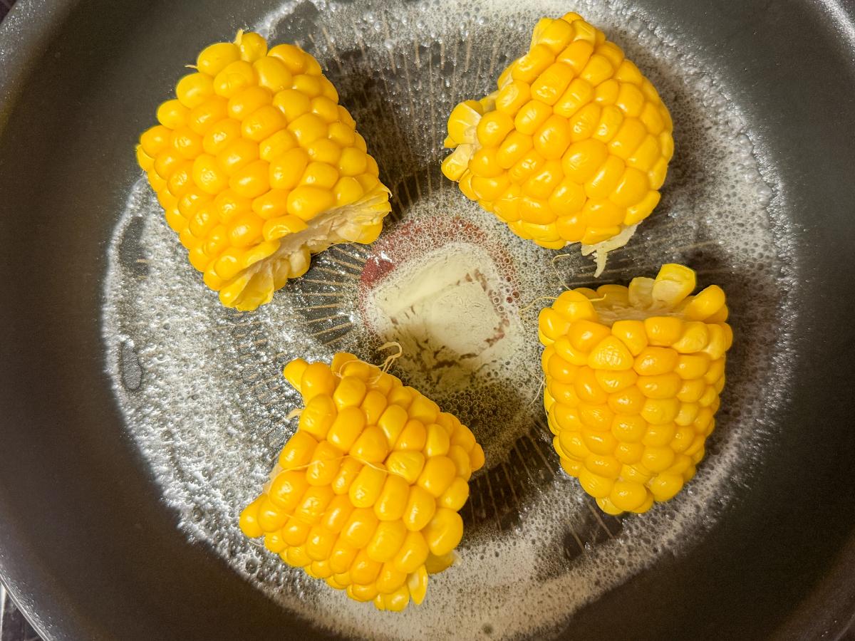 フライパンでバターを溶かしてとうもろこしを炒めているところ
