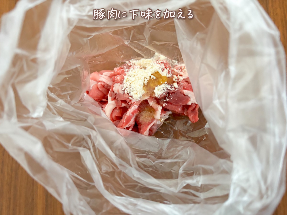 1）食品用ポリ袋に豚こま肉、鶏がらスープの素、塩、ごま油を入れ、袋の上から混ぜます。
