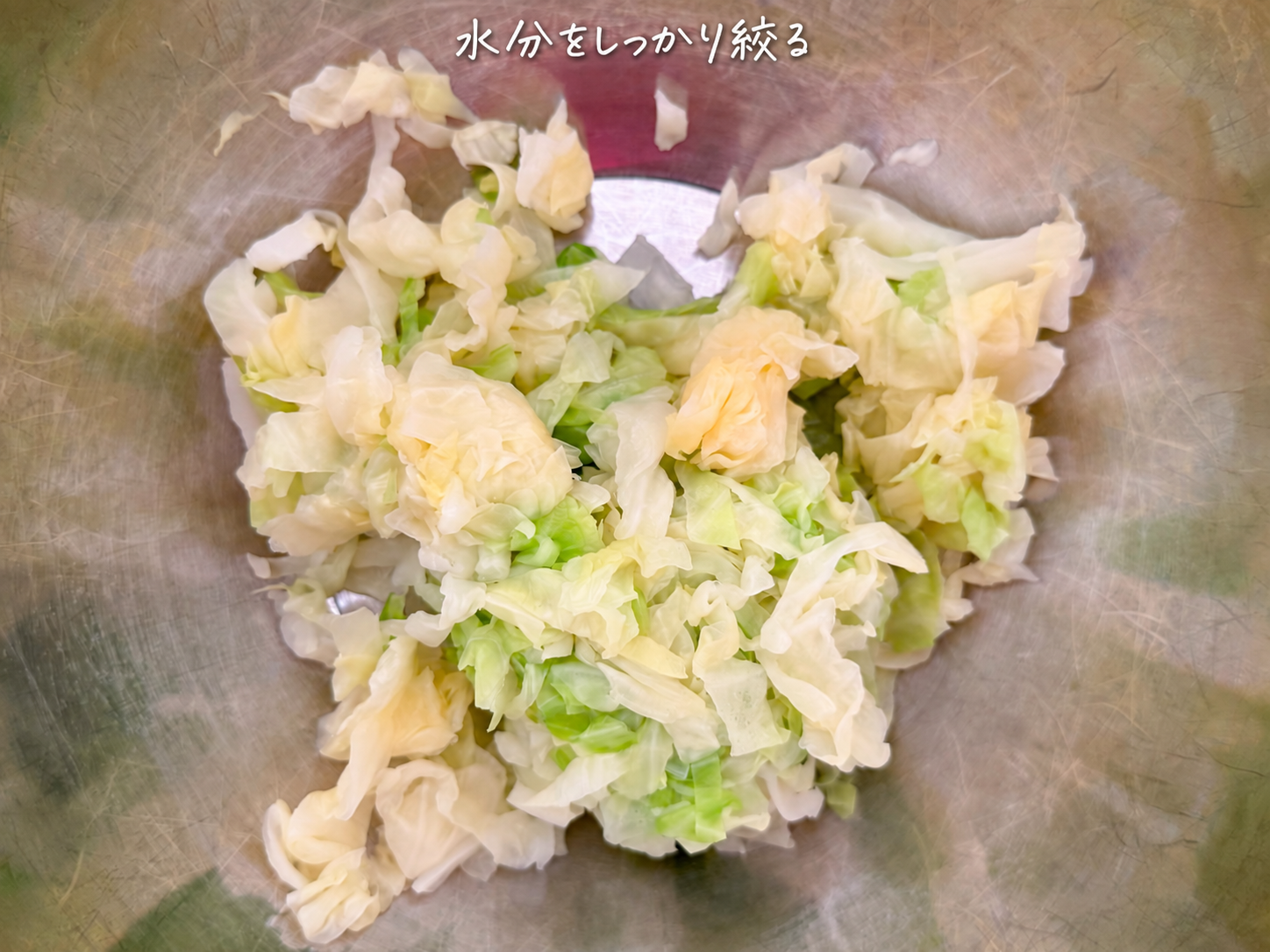 4)冷めたキャベツの水分をしっかりと絞り、ボウルに入れます。